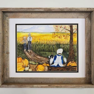 May include: A framed watercolor painting depicts a rural landscape with a golden wheat field, a tree with red fruit, and several pumpkins. Two figures in straw hats and overalls walk along a path, while a figure in a white bonnet sits near a dog.