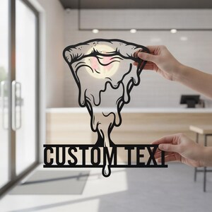 Könnte beinhalten: Ein schwarzes Metallschild in Form eines Pizzastücks mit herabtropfendem, geschmolzenem Käse. Der untere Bereich zeigt einen horizontalen Balken mit dem Schriftzug CUSTOM TEXT in fetten Großbuchstaben. Das Design wird vor einem hellen Hintergrund gehalten.