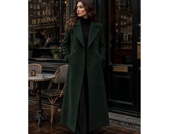 Könnte beinhalten: Ein langer, dunkelwaldgrüner zweireihiger Wollmantel mit breitem Revers, zwei Knopfreihen und tiefen Seitentaschen. Der Mantel wird über einem schwarzen Rollkragenpullover und einer schwarzen Hose getragen, was eine strukturierte Silhouette ergibt.