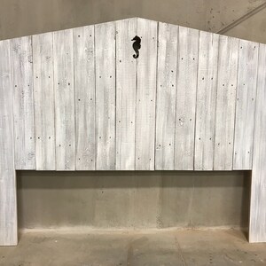 Puede incluir: Cabecero de madera blanqueada con un recorte de caballito de mar en el centro. El cabecero est&aacute; hecho de madera recuperada y tiene un estilo r&uacute;stico y de granja.