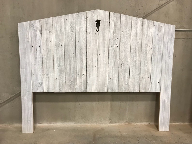Puede incluir: Cabecero de madera blanqueada con un recorte de caballito de mar en el centro. El cabecero est&aacute; hecho de madera recuperada y tiene un estilo r&uacute;stico y de granja.