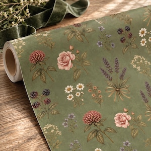 Pu&ograve; includere: Un rotolo di carta da regalo con sfondo verde salvia e un motivo botanico ripetuto di rose rosa, rametti di lavanda viola legati con nastri, margherite bianche e more scure con foglie e steli verdi.
