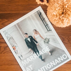 Könnte beinhalten: Ein rechteckiges Magazin-Cover mit dem Titel Marriage at Montignano, datiert auf Juli/August 2025. Das Cover zeigt ein Foto eines Paares, das im Freien an einer großen Steinsäule vorbeigeht, wobei eine Person einen schwarzen Anzug und die andere ein weißes Kleid mit Blumenstrauß trägt.