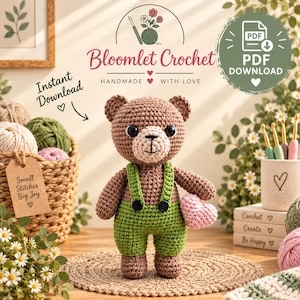 Puede incluir: Un oso de peluche tejido a ganchillo de color marrón con un peto verde y botones negros, que sostiene un pequeño corazón tejido a ganchillo de color rosa. La imagen incluye el texto Bloomlet Crochet, Instant Download y PDF Download.