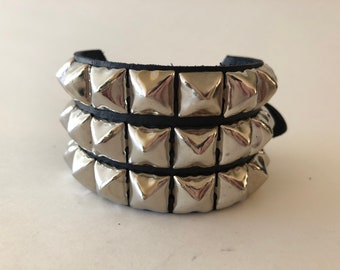 Armband met 3 rijen piramidevormige studs / verkrijgbaar met gesp of drukknoop