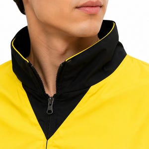 Close-up of high black collar and front zipper on men's yellow and black bomber jacket worn by a male model