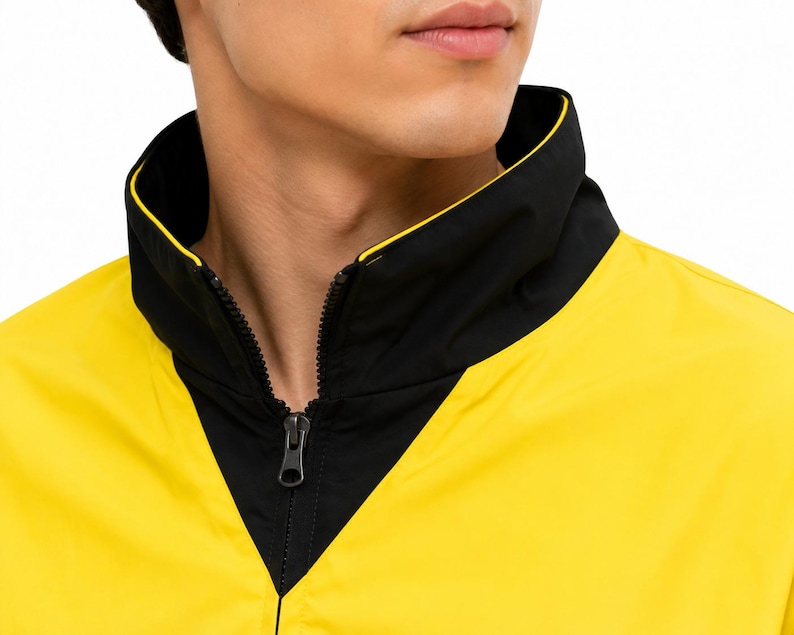 Close-up of high black collar and front zipper on men's yellow and black bomber jacket worn by a male model