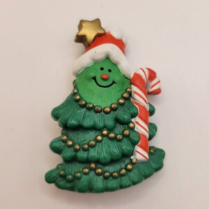 Pin de plástico retro de árbol de Navidad sonriente de Hallmark Cards: Árbol de Navidad feliz decorado con bastón de caramelo, gorro de Papá Noel y broche de estrella - K#400