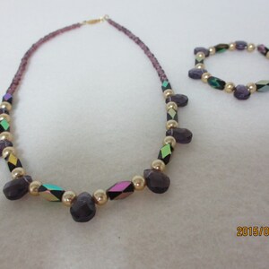Cute purple, gold, and iridescent stone necklace with matching bracelet.