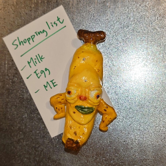 A hand-sculpted air-dry clay banana that's intentionally ugly and proud of it — tiny, absurd fridge art that sparks instant joy.