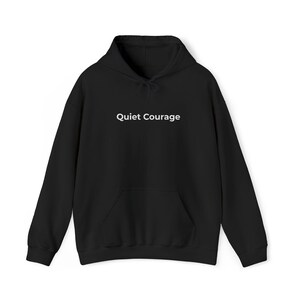 Peut inclure: Un sweat-shirt à capuche noir à manches longues avec une poche kangourou sur le devant et le texte Quiet Courage imprimé en blanc au centre de la poitrine. Le vêtement comprend une capuche à cordon et des bords-côtes aux manches et à la base.