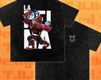 May include: A black acid-wash t-shirt featuring a graphic on the back of a muscular character in red and gold armor with the text LA REINA over a white block background. The front of the shirt displays a small white line-art icon of a helmeted head.