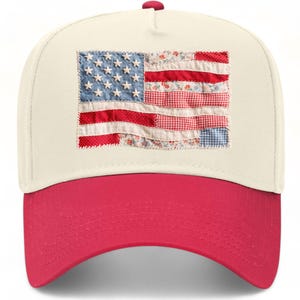 May include: A cream-coloured baseball cap with a bright red brim. The front panel features a rectangular patch designed to look like an American flag, constructed from various fabric scraps in red, white, and blue with floral and gingham patterns.