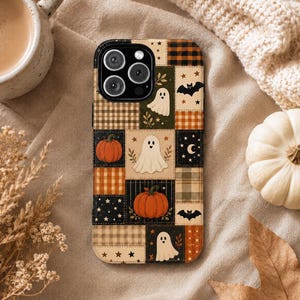 May include: A smartphone case featuring a patchwork design of autumn and Halloween motifs. The pattern includes white ghosts, orange pumpkins, black bats, stars, and crescent moons set against various plaid, checkered, and solid colored squares.