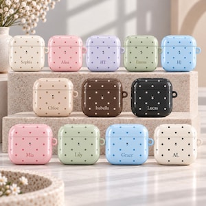 May include: A collection of twelve square earbud cases in various pastel and dark colors, each featuring a polka dot pattern and a personalized name or initials printed on the front. The cases include a small circular cutout for charging ports.