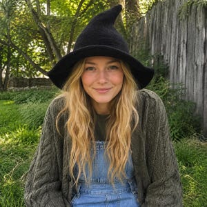 Peut inclure: Un chapeau de sorcière en tricot noir avec une couronne pointue et un large bord légèrement incurvé. Le chapeau est fabriqué dans une matière sombre et texturée, présentant un sommet conique structuré qui se termine en pointe, d'un noir uni.
