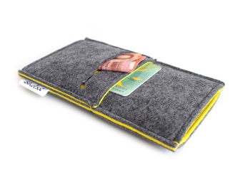 May include: A gray felt wallet with yellow stitching and the word "bholsi" printed on the front. The wallet has a pocket for cash and a slot for a card.