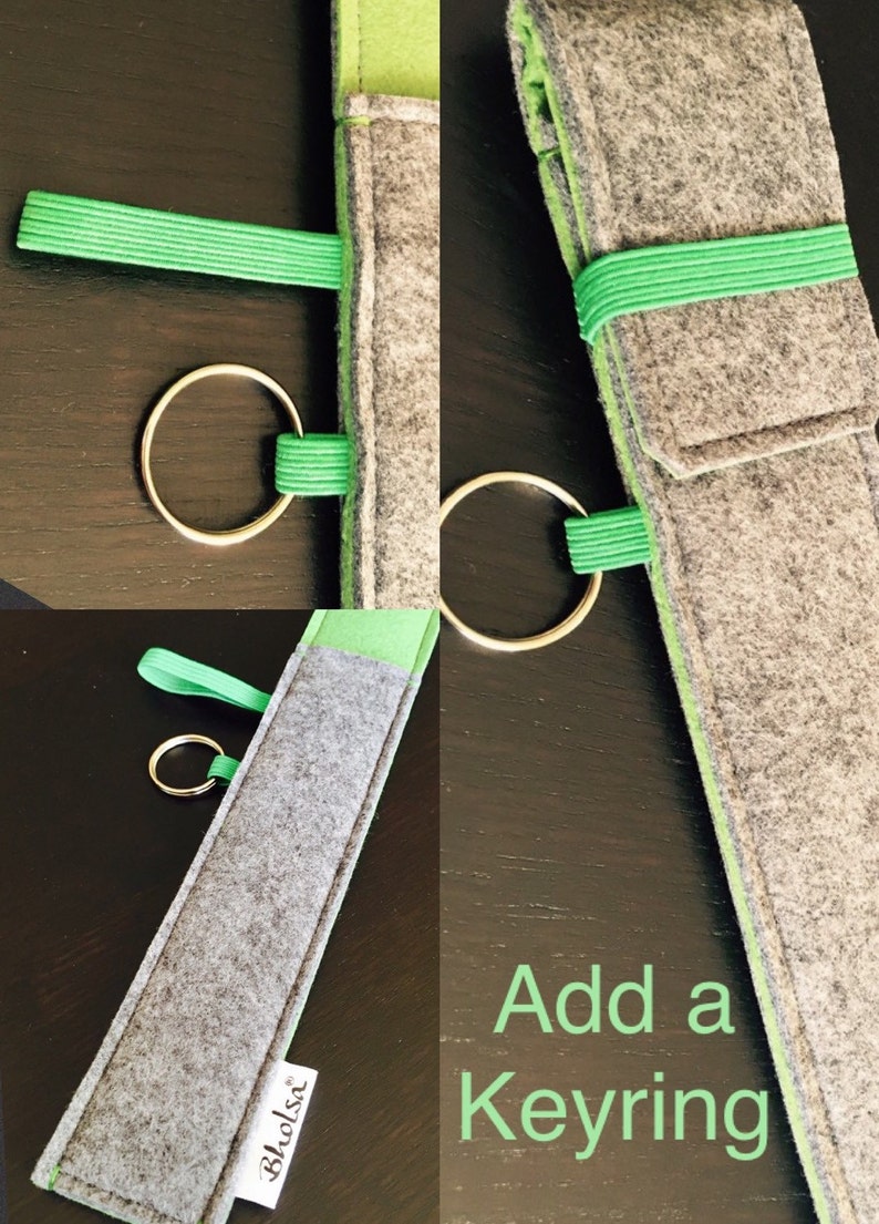 May include: A gray felt case with a bright green interior and elastic band, designed to hold items. A gold-colored keyring is attached. The text "Add a Keyring" is visible in green.