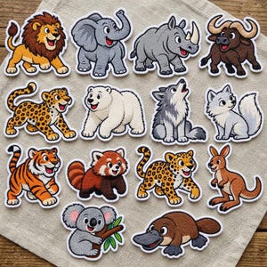 May include: A collection of fourteen embroidered animal patches featuring a lion, elephant, rhinoceros, buffalo, leopard, polar bear, wolf, fox, tiger, red panda, cheetah, kangaroo, koala, and platypus, all with white borders.