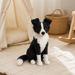 Peut inclure: Une peluche crochetée représentant un chien Border Collie. Le jouet est composé de fil noir et blanc, avec un poitrail, un museau et des pattes blancs, ainsi qu'un corps, des oreilles et une pointe de queue noirs. Il est assis avec des yeux sombres.