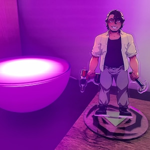 Op de afbeelding: Een cartoonfiguur van een persoon met een boor en een hamer. De figuur staat op een houten voet met een groene driehoek en een doorzichtig acryl platform. Op de achtergrond is een paars licht te zien.