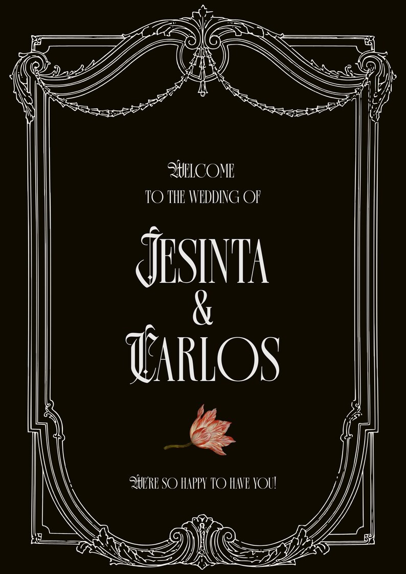 May include: A black rectangular wedding sign with a white ornate border. The text reads: WELCOME TO THE WEDDING OF JESINTA & CARLOS. A single pink and white flower is centered below the names, followed by the text: WE'RE SO HAPPY TO HAVE YOU!