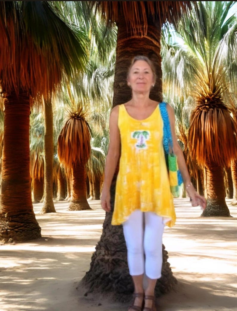 A woman wearing a yellow sleeveless top with a palm tree design
