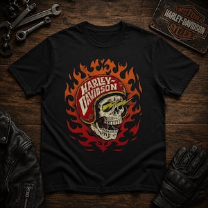 May include: A black short-sleeve t-shirt featuring a graphic of a skull wearing a red helmet with the text Harley-Davidson. The skull has yellow lightning bolts coming from its eyes and is surrounded by orange and red flames on the chest.