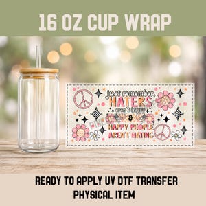 May include: A clear 16 oz glass cup with a bamboo lid and straw, accompanied by a rectangular UV DTF transfer sheet featuring pink and orange flowers, peace signs, and the text: just remember, HATERS aren't happy & HAPPY PEOPLE AREN'T HATING.