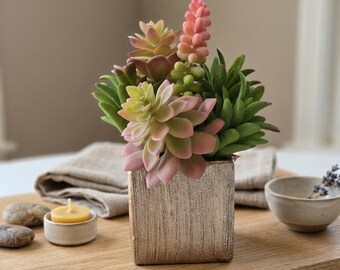 Kunstmatige succulenten als tafeldecoratie met een pot van bronskleurige textuur.