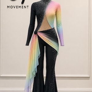 May include: A long-sleeved jumpsuit featuring a black bodice with a high neck and a rainbow gradient sleeve. The torso has a sheer mesh cutout, and the flared pants are black. The garment is embellished with crystals and a draped rainbow fabric sash.