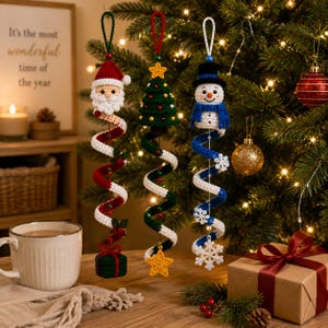 May include: Three crocheted hanging ornaments featuring a Santa Claus with a red and white spiral, a green Christmas tree with a yellow star and green spiral, and a snowman with a blue hat, scarf, and a blue and white spiral with snowflakes.