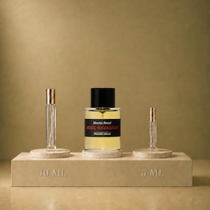 Może przedstawiać: Przezroczysty szklany flakon perfum z czarną nakrętką i etykietą z napisem Maurice Roucel MUSC RAVAGEUR EDITIONS DE PARFUMS FREDERIC MALLE, w towarzystwie dwóch mniejszych szklanych fiolek z rozpylaczami i nakrętkami w kolorze różowego złota na beżowej podstawce 10 ML i 5 ML.
