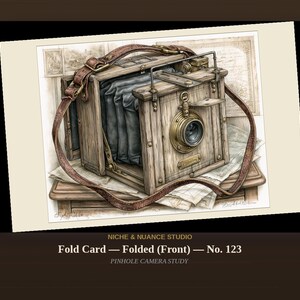 May include: A vintage-style wooden bellows camera illustration featuring a brown leather strap, a brass lens, and a black accordion-style bellows. The artwork includes the text NICHE & NUANCE STUDIO, Fold Card — Folded (Front) — No. 123, and PINHOLE CAMERA STUDY.