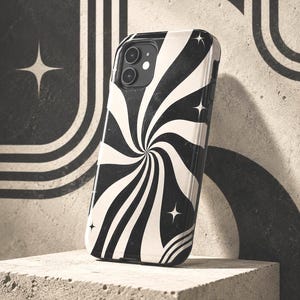 May include: A black and white phone case featuring a swirling radial pattern that radiates from the center. The design includes small four-pointed star icons scattered across the surface, with a cutout for the dual camera lens at the top.