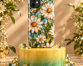 May include: A smartphone case featuring a stained glass style design of white daisies with yellow centers, green leaves, and blue accents. The case has a black camera cutout and is displayed on a cylindrical yellow and green stand.