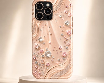 May include: A rose gold smartphone case featuring a swirling, liquid-like texture and an array of embedded clear and pink crystals. The case includes a prominent camera cutout with three circular lenses and a flash, with crystal accents.