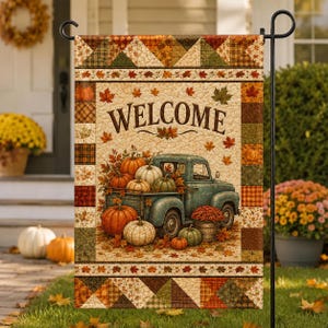 May include: A rectangular garden flag featuring a teal vintage pickup truck carrying pumpkins and mums. The center displays the word WELCOME in brown text, surrounded by autumn leaves. The border has a patchwork quilt pattern in fall colors.