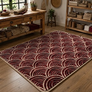 Alfombra geométrica color burdeos tejida a mano, con diseño de arcos color crema, ideal para la decoración de una sala de estar moderna.