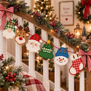 Op de afbeelding: Een kerstslinger met vilten ornamenten van een kabouter, een rendier, de Kerstman, een kerstboom, een sneeuwpop en een kerstsok, allemaal aan een rood koord. De ornamenten zijn versierd met rood-wit ruitpatroon en effen kleuren.