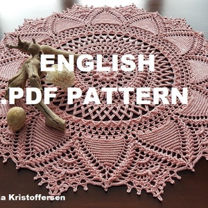 May include: A pink crochet doily with a delicate lace pattern. The doily is on a wooden surface and has the text "ENGLISH PDF PATTERN" in white letters.