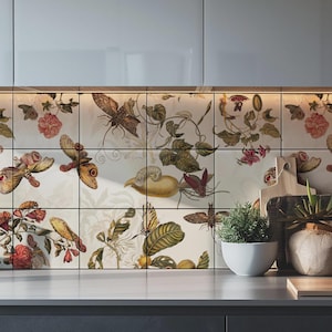 Può includere: Un paraschizzi da cucina composto da piastrelle quadrate decorate con una stampa botanica e di insetti. Il design include illustrazioni dettagliate di falene, farfalle, foglie verdi e fiori rossi su uno sfondo color crema.