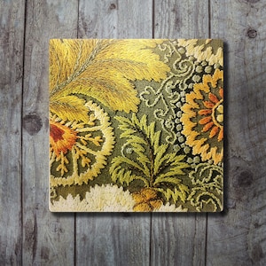 Könnte beinhalten: Ein quadratischer Untersetzer mit aufwendiger Stickerei auf einem dunkel olivgrünen Stoffuntergrund. Das Design zeigt stilisierte Blumen- und Blattmuster in leuchtenden Goldgelb-, Senf- und Rostorangetönen mit texturierten Stichen.