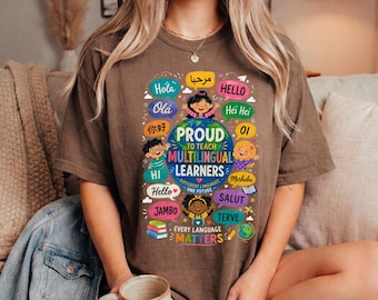 May include: A brown short-sleeve t-shirt featuring a graphic of the Earth surrounded by speech bubbles with greetings in various languages. The text reads Proud to Teach Multilingual Learners, Different Languages One Future, and Every Language Matters.