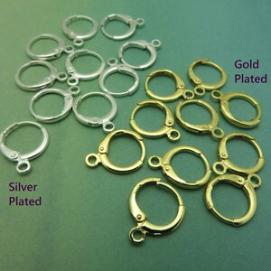 May include: A close-up of two groups of earring hoops. The left group is silver plated and the right group is gold plated. The hoops are all the same size and shape.