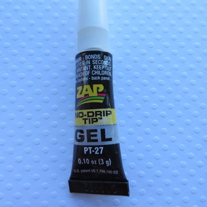 May include: A small black tube of ZAP No-Drip Tip Gel adhesive with a white cap. The tube is labeled with the product name, "PT-27", and the size, "0.10 oz (3 g)".