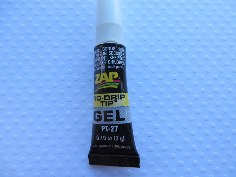 May include: A small black tube of ZAP No-Drip Tip Gel adhesive with a white cap. The tube is labeled with the product name, "PT-27", and the size, "0.10 oz (3 g)".