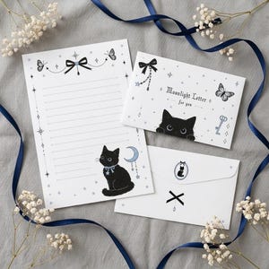 May include: A stationery set featuring a lined letter sheet, a folded card, and an envelope. The white paper is decorated with black cat illustrations, blue crescent moons, butterflies, stars, and bows. The card displays the text Moonlight Letter for you.