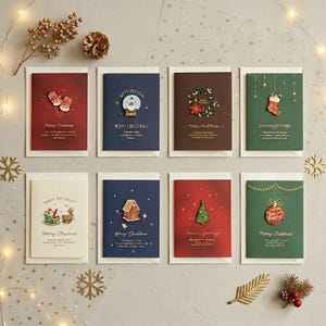Könnte beinhalten: Ein Set aus acht rechteckigen Weihnachtsgrußkarten in verschiedenen Farben wie Rot, Blau, Braun und Grün. Jede Karte zeigt ein kleines, erhabenes festliches Symbol wie einen Schneemann, einen Strumpf oder einen Baum sowie gedruckte Weihnachtsgrüße.