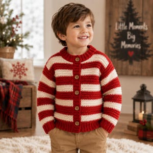 May include: A long-sleeved, button-down cardigan featuring horizontal stripes in deep red and cream. The knit garment has a round neckline, ribbed cuffs, and a ribbed hem, secured by five brown buttons down the centre front placket.
